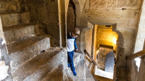 Plentyn yn dringo grisiau canoloesol Tŵr Adam yng Nghastell y Waun, Wrecsam